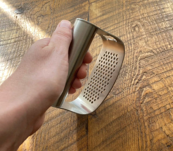 Garlic press rocker that crushes garlic by rocking back and forth